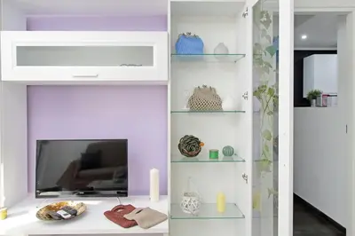 a living room with a tv and a shelf at Makà, una struttura dal fascino unico in Rome