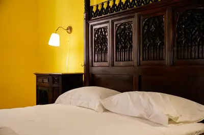 a bed with a wooden head board and two pillows at Residenza Ducale in Rome