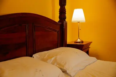 a bed with a wooden head board next to a lamp at Residenza Ducale in Rome