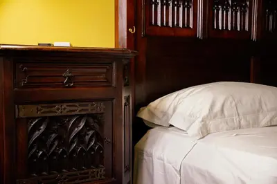 a bedroom with a bed and a wooden dresser with a white pillow at Residenza Ducale in Rome