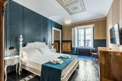 a bedroom with a bed with a blue wall at Rome As You Feel - Maison Torre Argentina - Arenula 41 in Rome