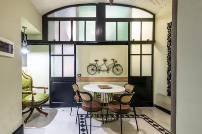 a room with a table and chairs and a bike on the wall at Rome As You Feel - Maison Torre Argentina - Arenula 41 in Rome