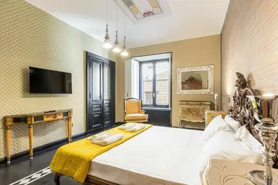 a large room with a bed and a tv at Rome As You Feel - Maison Torre Argentina - Arenula 41 in Rome