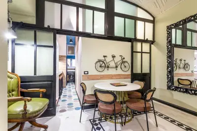 a room with a table and chairs and windows at Rome As You Feel - Maison Torre Argentina - Arenula 41 in Rome