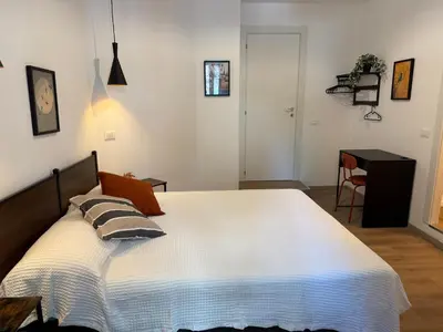 a bedroom with a large white bed and a desk at B&B Loggia Garbatella in Rome