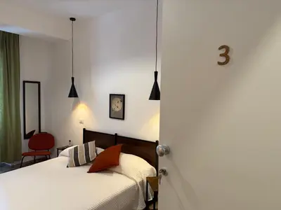 a bedroom with a bed and a red chair at B&B Loggia Garbatella in Rome