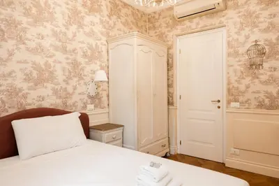 a bedroom with a white bed and a cabinet at Candy Lodge in Rome