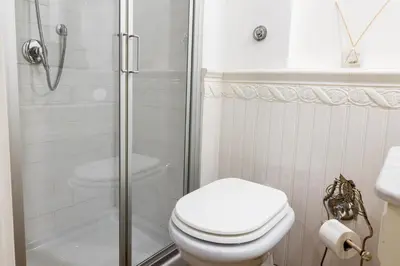 a white bathroom with a toilet and a shower at Candy Lodge in Rome