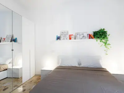a white bedroom with a bed and a mirror at Enjoy Rome San Paolo Retreat in Rome