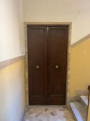 a large wooden door in a room with stairs at Enjoy Rome San Paolo Retreat in Rome