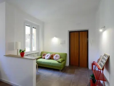a living room with a green couch and a window at Enjoy Rome San Paolo Retreat in Rome