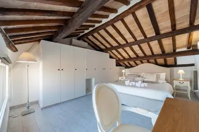 a bedroom with a bed and a table and a chair at Renovated Luxury Sweet Penthouse - Campo Dei Fiori in Rome