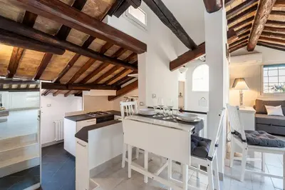 a kitchen with white walls and wooden ceilings at Renovated Luxury Sweet Penthouse - Campo Dei Fiori in Rome