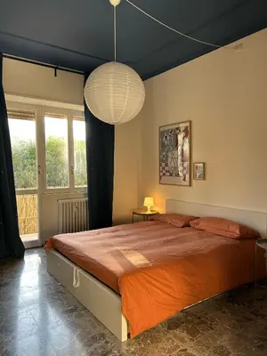 a bedroom with a large bed and a large lamp at Casa Troccoli in Rome