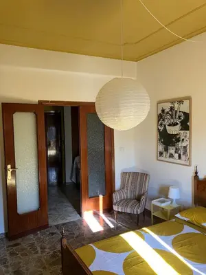 a bedroom with a bed and a chair and a lamp at Casa Troccoli in Rome