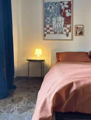 a bedroom with a bed and a table with a lamp at Casa Troccoli in Rome