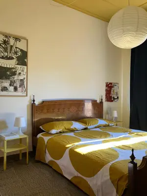 a bedroom with a large bed with a yellow and blue comforter at Casa Troccoli in Rome