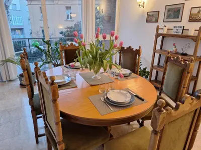 a wooden table with chairs and a table with flowers on it at Apartment Rome Parioli near Villa Borghese in Rome