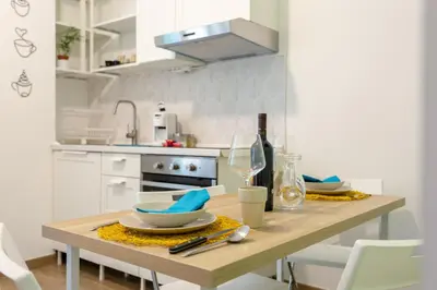 a kitchen with a wooden table with dishes on it at Maison Manú - Vaticano in Rome