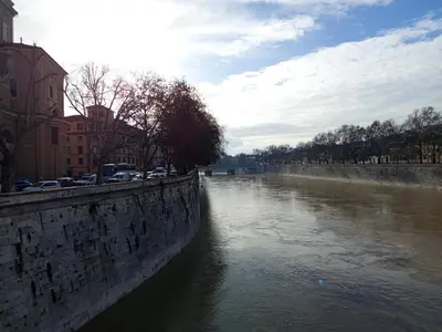 a river with cars parked on the side of it at Maison Manú - Vaticano in Rome