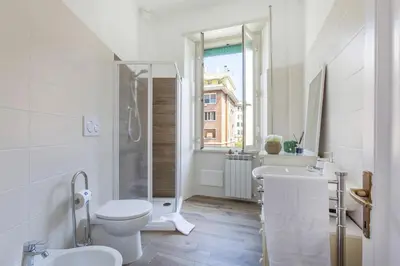 a white bathroom with a toilet and a sink at Domus Latina heart San Giovanni in Rome