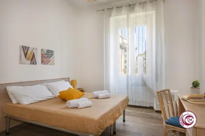a bedroom with a bed with two towels on it at Domus Latina heart San Giovanni in Rome