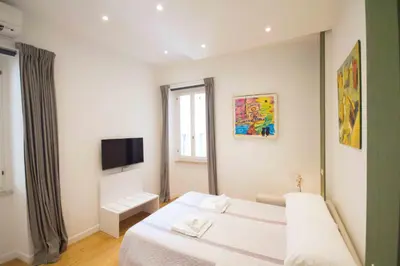 a bedroom with a white bed and a large mirror at Corso 277 Apartment in Rome