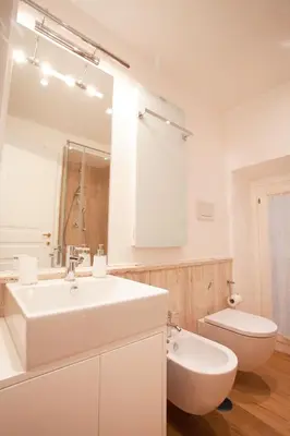a white bathroom with a sink and a toilet at Corso 277 Apartment in Rome