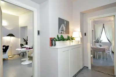 a white living room with a table and a dining room at Residenza Romana Zucchelli in Rome