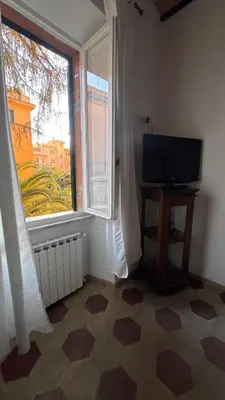 a living room with a television and a large window at Casa Francesco in Rome