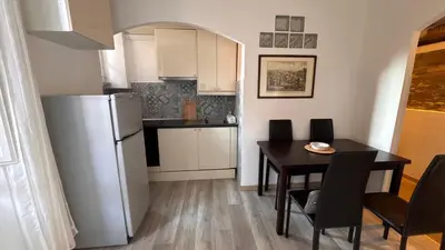 a kitchen and dining room with a table and a refrigerator at Casa Francesco in Rome