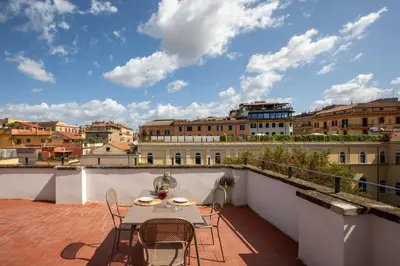 a patio with a table and chairs on a balcony at iFlat Scenic Penthouse with Terrace near Vatican in Rome