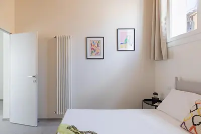 a bedroom with a white bed and two pictures on the wall at iFlat Scenic Penthouse with Terrace near Vatican in Rome