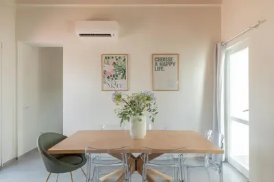 a dining room table with a vase of flowers on it at iFlat Scenic Penthouse with Terrace near Vatican in Rome