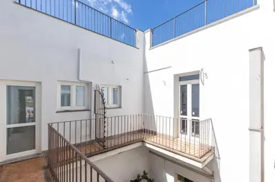 a balcony of a white building with a staircase at iFlat Scenic Penthouse with Terrace near Vatican in Rome