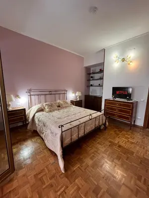 a bedroom with a bed and two night stands and a television at Vatican Lodge in Rome