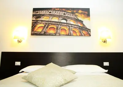 a bedroom with a bed with a picture on the wall at Le tue Notti a San Pietro in Rome