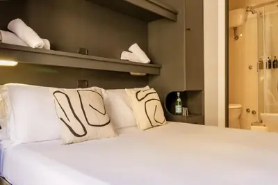a bedroom with a white bed and a shower at Cunabu Calatafimi in Rome