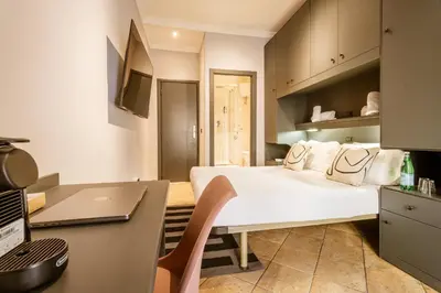 a hotel room with a bed and a desk at Cunabu Calatafimi in Rome