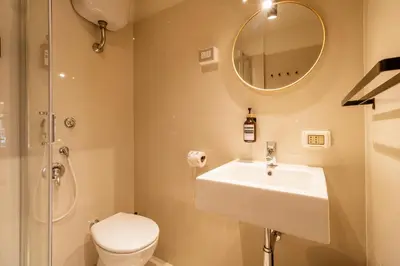 a bathroom with a sink and a toilet and a mirror at Cunabu Calatafimi in Rome
