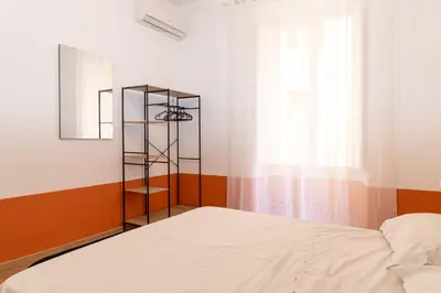a bedroom with a bed and a mirror and a window at Boutique apartment 10 min to Colosseum and Termini in Rome