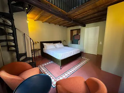 a bedroom with a bed and two chairs at Trastevere Luxury Apartment in Rome