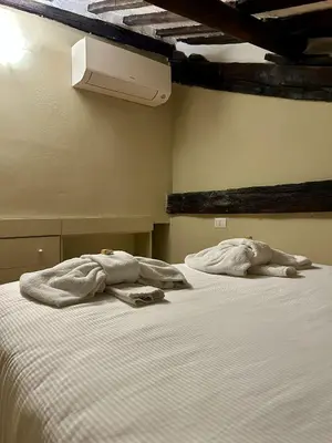 a bed with white sheets and towels on it at Trastevere Luxury Apartment in Rome