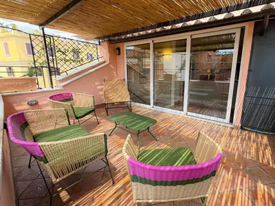 a patio with chairs and tables on a deck at Trastevere Luxury Apartment in Rome