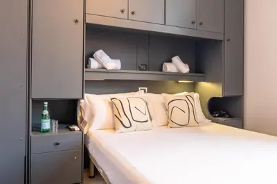a bedroom with a bed with white pillows at Cunabu Castro Pretorio in Rome