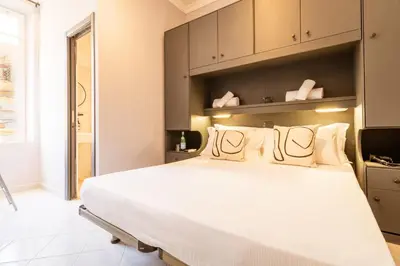 a bedroom with a large white bed and cabinets at Cunabu Castro Pretorio in Rome