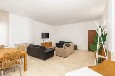 a living room with two couches and a table at ATRHOME- Penthouse Tritone in Rome