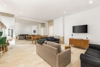 a living room with a couch and a tv on a wall at ATRHOME- Penthouse Tritone in Rome