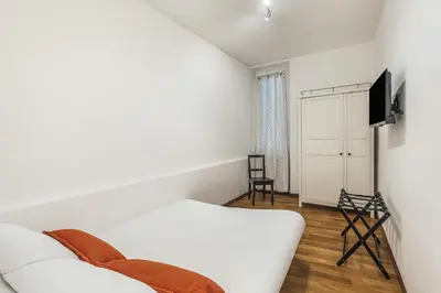 a white bedroom with a bed and a tv at ATRHOME- Penthouse Tritone in Rome