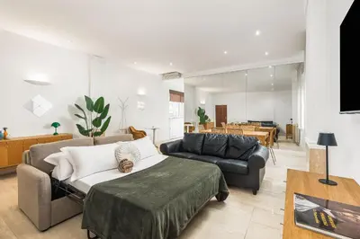 a living room with a bed and a couch at ATRHOME- Penthouse Tritone in Rome